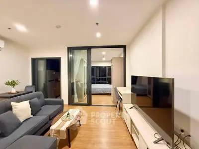 Modern living room with open layout and stylish decor, featuring a view into a cozy bedroom.