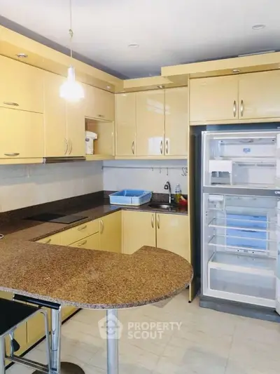 Modern kitchen with yellow cabinets and open fridge in stylish apartment