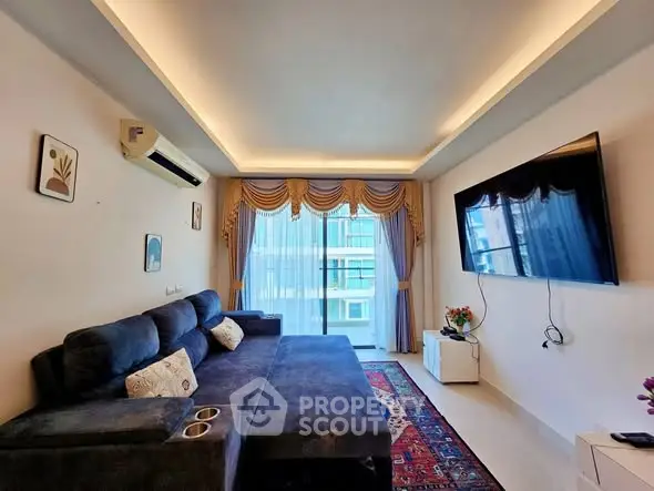 Spacious living room with modern decor and large TV, perfect for relaxation.