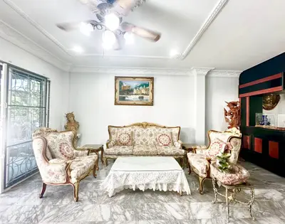 Elegant living room with classic furniture and marble flooring, perfect for luxurious gatherings.