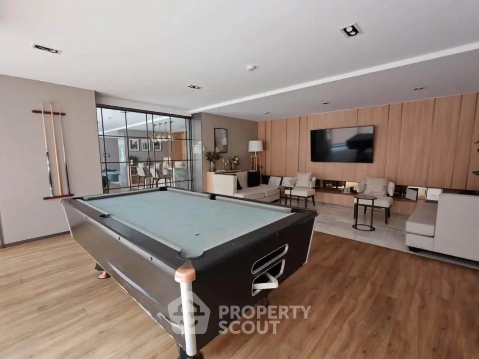 Spacious living room with pool table and modern decor, perfect for entertainment.