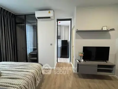 Modern bedroom with cozy decor and open view to kitchen area