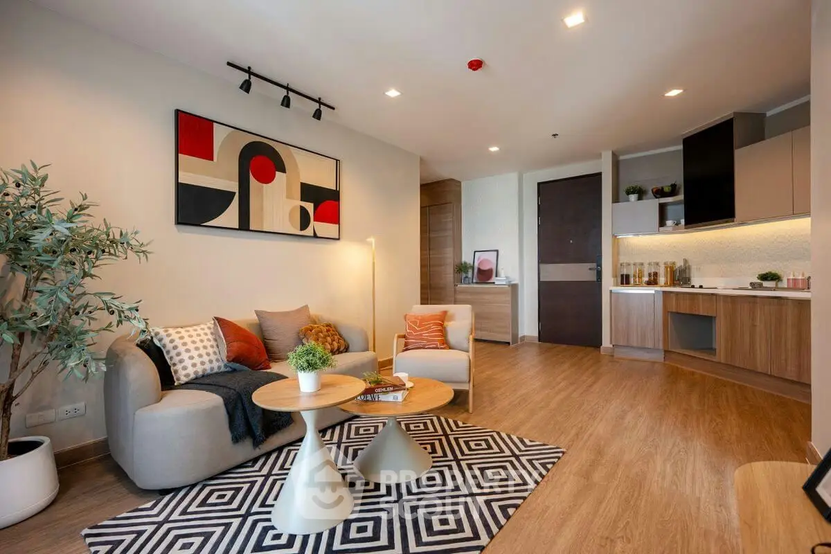 Modern living room with stylish decor and open kitchen layout, featuring cozy seating and contemporary artwork.
