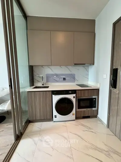 Modern kitchen with sleek appliances and marble flooring in a stylish apartment.