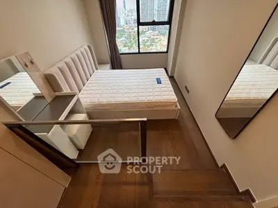 Modern bedroom with city view, featuring a stylish bed and wooden flooring.