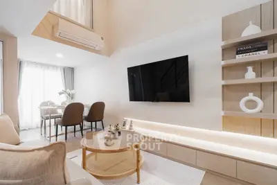 Modern living room with stylish decor and open dining area, featuring a wall-mounted TV and elegant shelving.