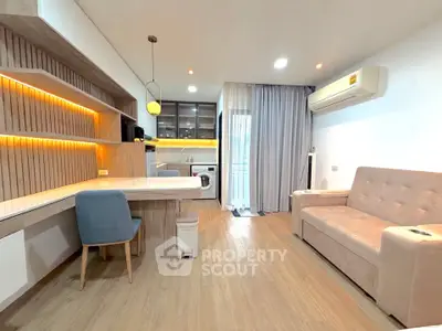 Modern living room with stylish furniture and open layout, featuring a cozy sofa and elegant lighting.