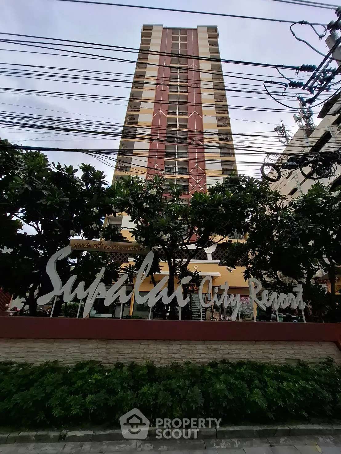 Stunning high-rise building at Supalai City Resort with lush greenery and modern architecture.