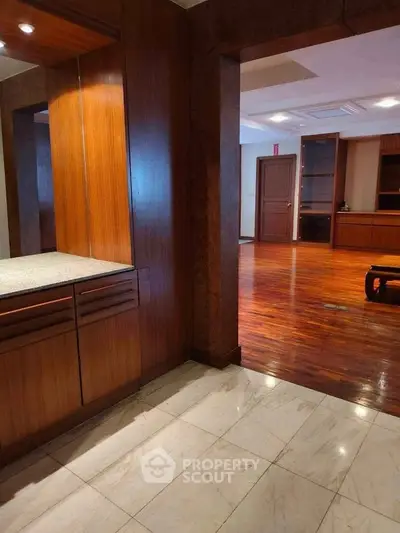 Spacious living area with elegant wooden flooring and built-in cabinetry, perfect for modern living.