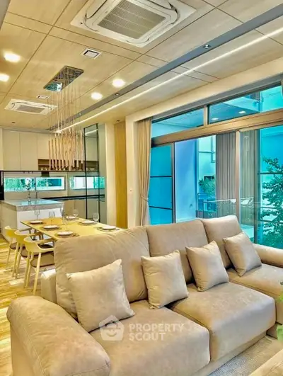 Luxurious open-layout living room with modern kitchen and large windows