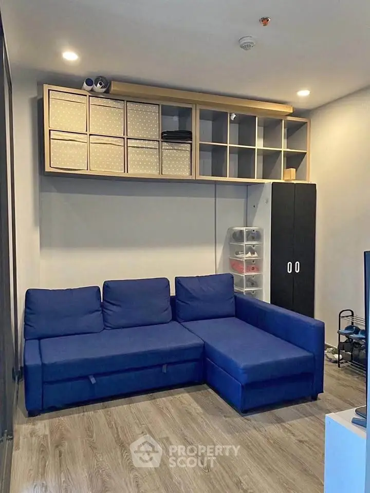 Modern living room with blue sectional sofa and stylish storage solutions.