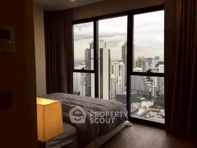 Luxurious bedroom with stunning city view from floor-to-ceiling windows.