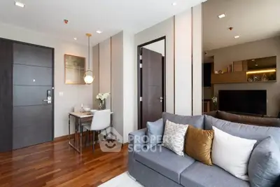 Modern living room with elegant decor and dining area, featuring wooden flooring and stylish furniture.