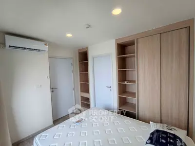 Modern bedroom with built-in wooden closets and air conditioning in a bright apartment.
