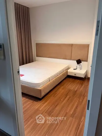 Cozy bedroom with wooden flooring and modern furnishings, perfect for relaxation and comfort.