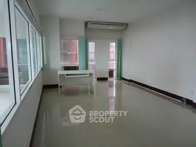 Spacious unfurnished room with large windows and air conditioning unit
