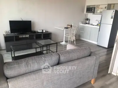 Modern open-plan living room with kitchen, featuring sleek furniture and contemporary design.