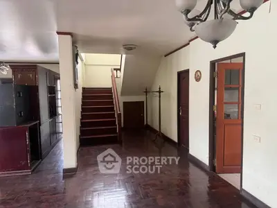 Spacious interior with wooden flooring and staircase in a cozy home.