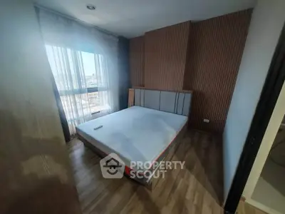 Modern bedroom with large window and stylish wooden paneling, perfect for urban living.