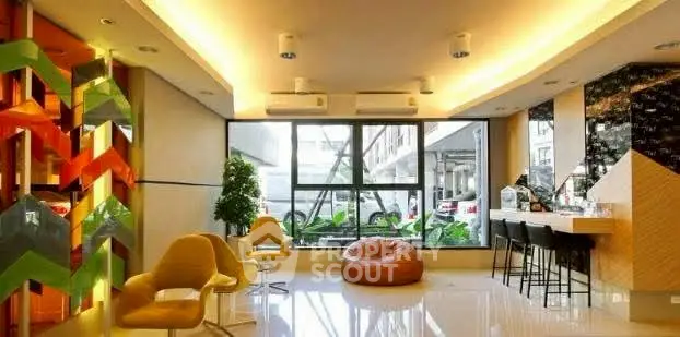 Modern living room with vibrant decor and large windows in a stylish apartment.