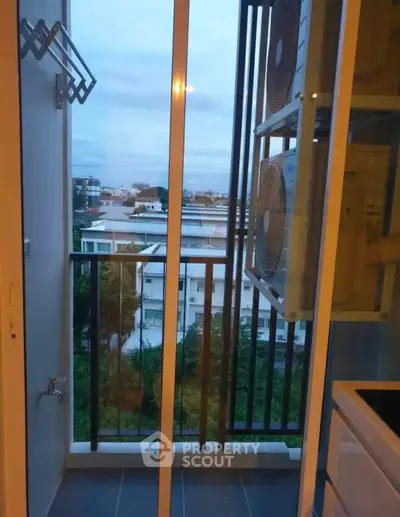 Compact balcony with city view and air conditioning units, perfect for urban living.