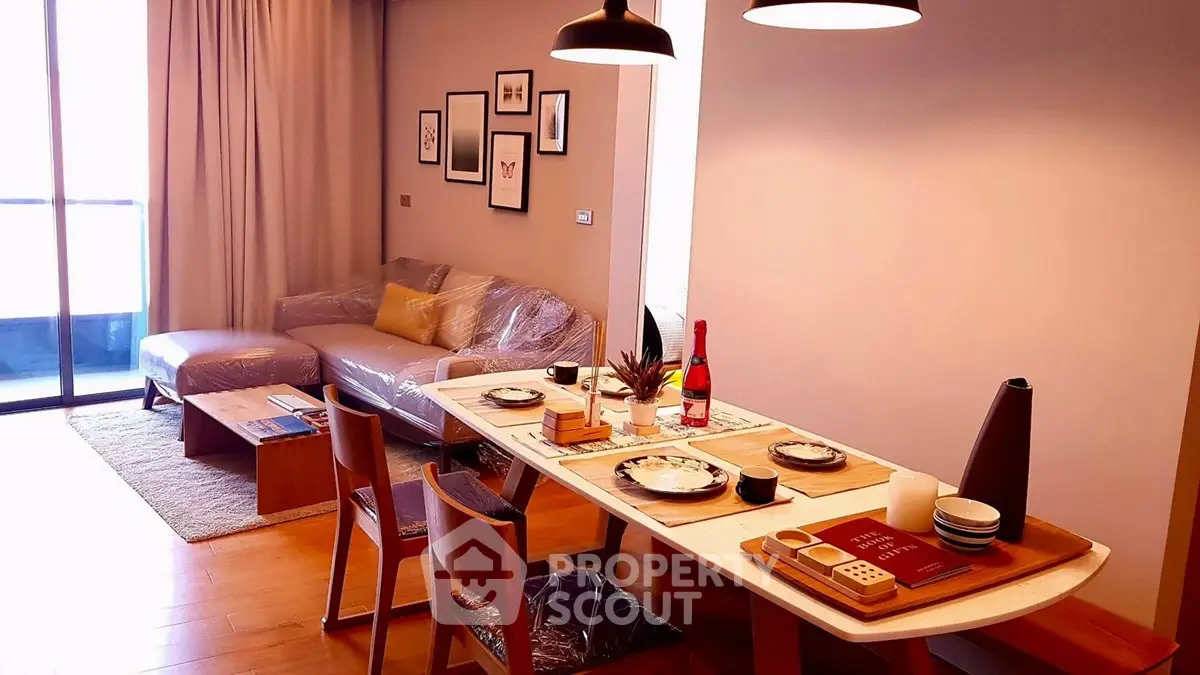 Modern living room with dining area, stylish decor, and natural light from balcony.