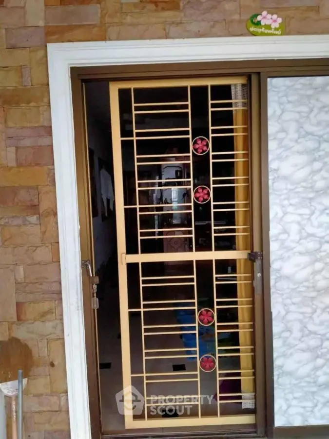 Stylish entrance with decorative metal door and stone wall accents
