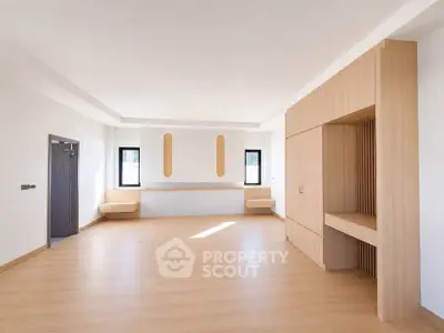 Spacious modern living room with wooden flooring and built-in storage