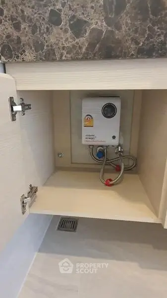 Compact under-sink water heater in modern kitchen cabinet
