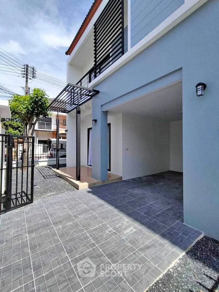 Modern two-story house with spacious driveway and sleek exterior design.