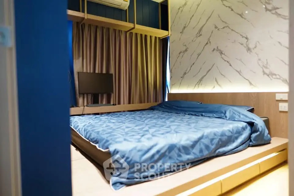 Modern bedroom with stylish marble accent wall and cozy blue bedding