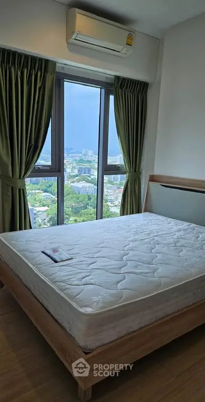 Spacious bedroom with large window offering stunning city views, featuring a comfortable bed and modern air conditioning.