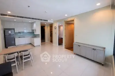 Spacious modern living room with open kitchen layout and sleek furnishings.