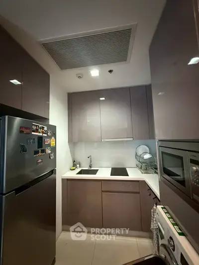 Modern compact kitchen with sleek cabinets and built-in appliances