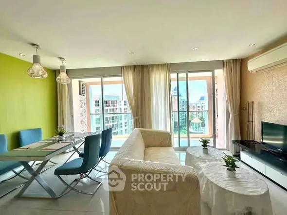 Spacious living room with modern decor and large windows offering a stunning city view.