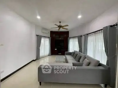 Spacious living room with modern gray sectional sofa and large windows for natural light.