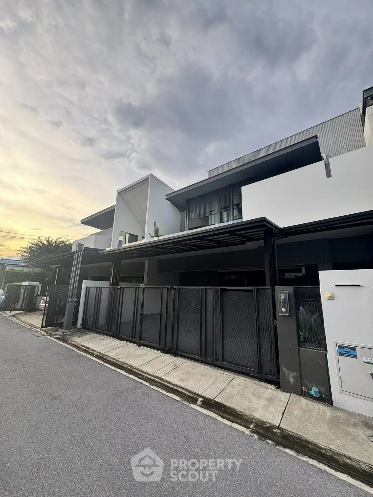 Modern architectural exterior of a stylish residential building at sunset.