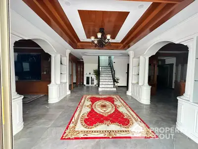 Luxurious entrance with elegant chandelier and grand staircase in a spacious home