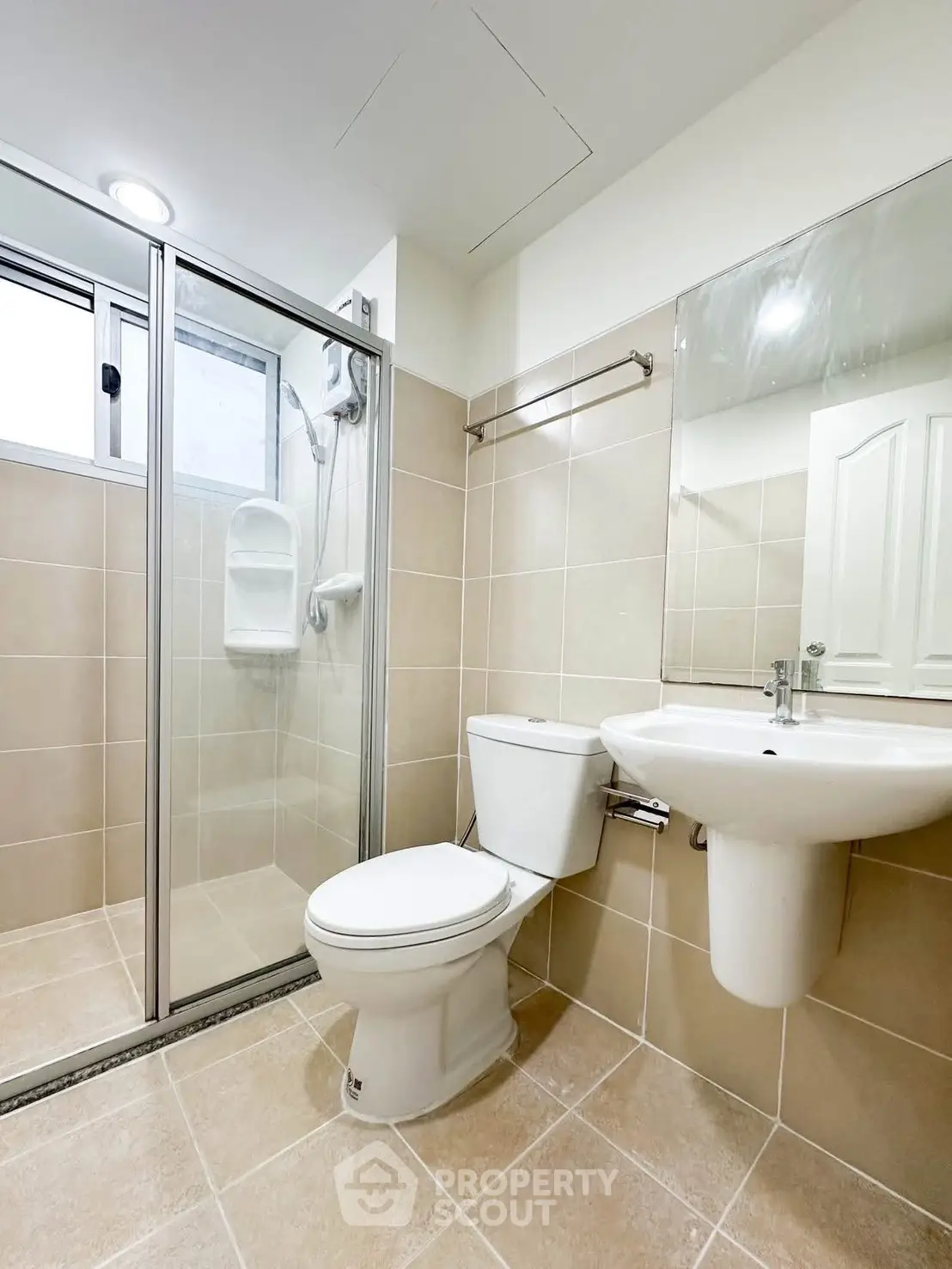 Modern bathroom with glass shower, sleek fixtures, and neutral tiles for a clean, contemporary look.