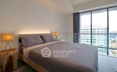 Modern bedroom with large windows offering stunning city views, featuring stylish decor and cozy ambiance.