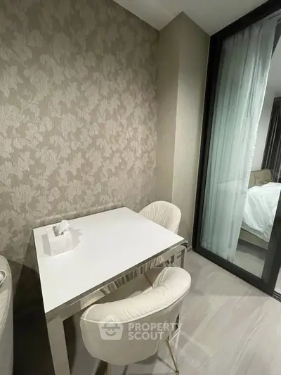 Modern dining nook with elegant wallpaper and plush chairs in a stylish apartment.