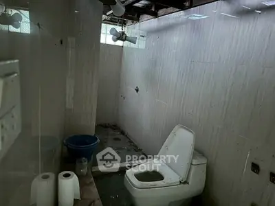 Unfinished bathroom with exposed ceiling and basic fixtures, potential for renovation.