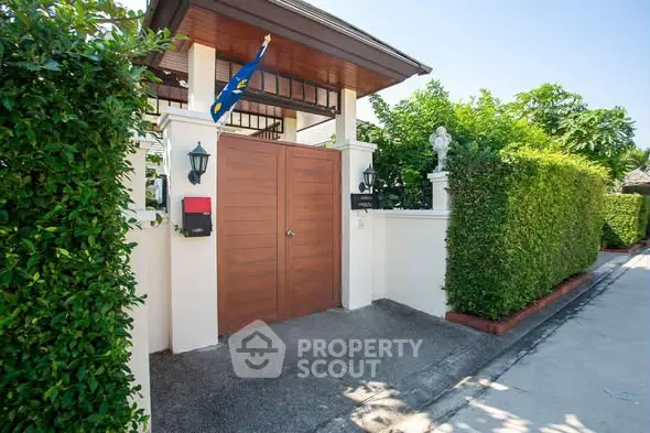 Charming gated entrance with lush greenery and modern design.