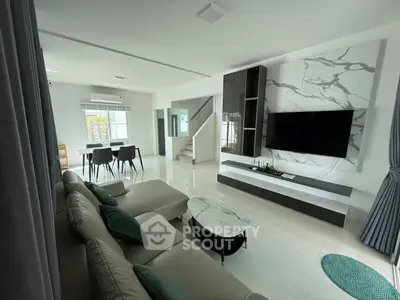 Spacious modern living room with elegant marble accent wall and sleek furniture