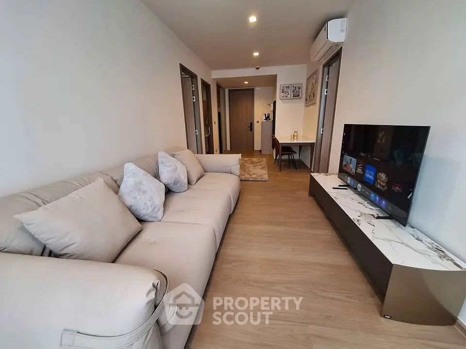 Spacious modern living room with plush sofa and sleek TV unit, perfect for relaxation and entertainment.