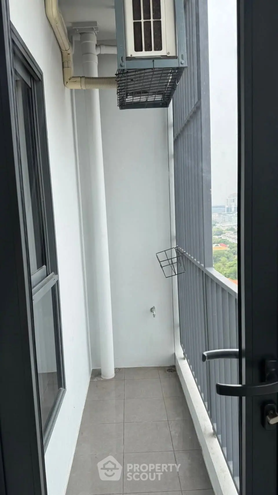 Compact balcony with city view, ideal for urban living in high-rise apartment.