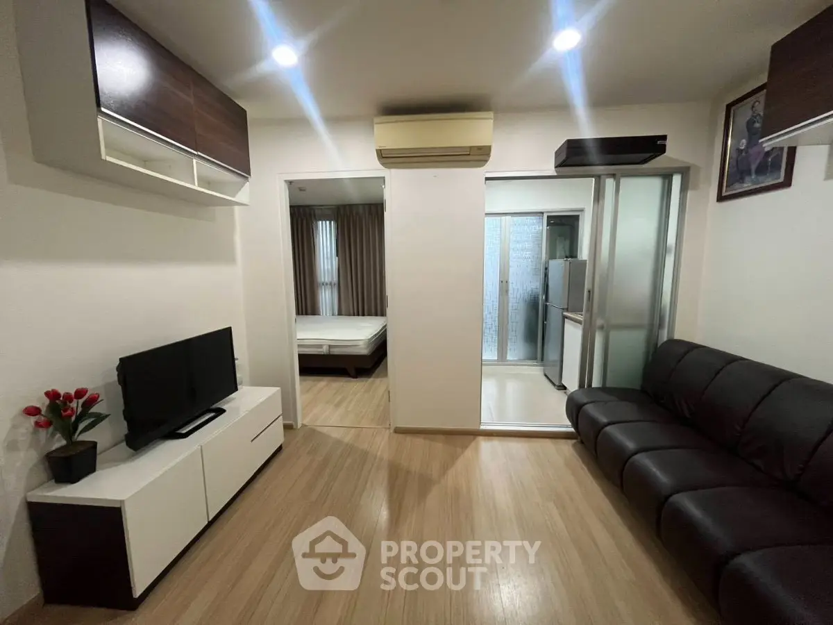 Modern living room with sleek furniture and open view to bedroom, perfect for urban living.
