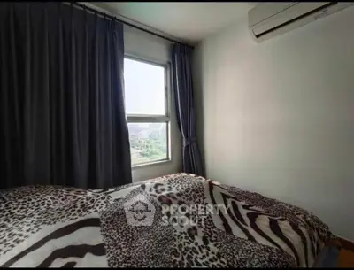 Cozy bedroom with large window and air conditioning, featuring stylish animal print bedding.