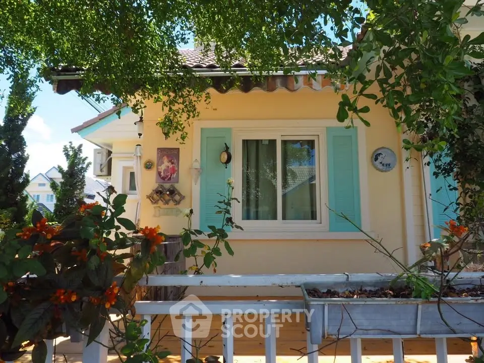 Charming house exterior with pastel shutters and lush greenery