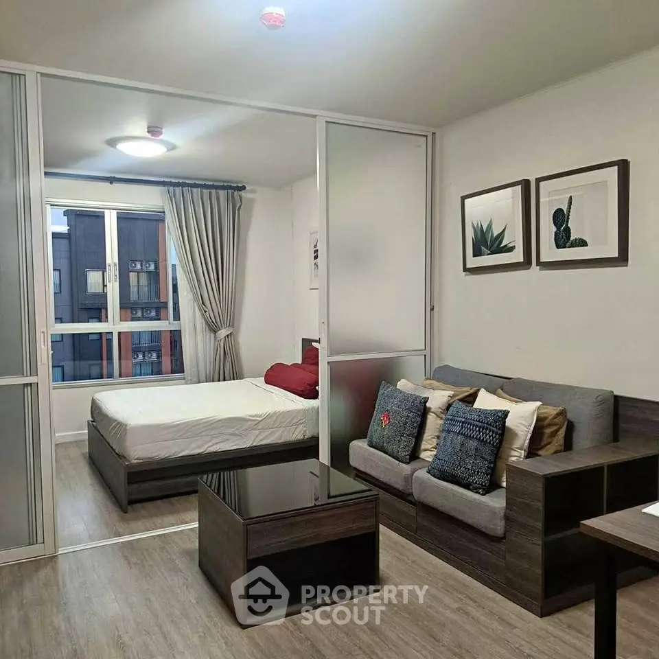 Modern studio apartment with cozy living area and bedroom, featuring stylish decor and natural light.